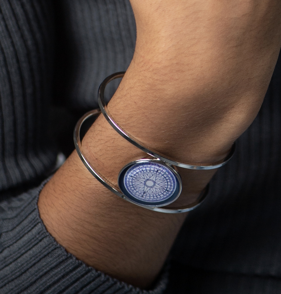 bracelet featuring a blue compass design on a person's wrist